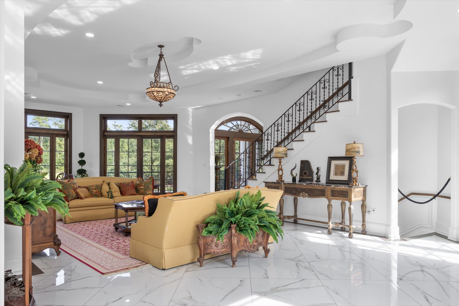 Living room with staircase and tall windows